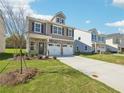 Beautiful two-story house showcasing a brick front, two-car garage, and an expansive green lawn at 11854 Rizvan Pl, Covington, GA 30014