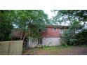 Rear exterior view of a brick house with a small deck and a stone foundation at 1398 Christmas Ne Ln, Atlanta, GA 30329