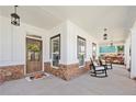 Inviting front porch featuring rocking chairs, brick accents, and stylish lighting fixtures at 4044 Andover Cir, Mcdonough, GA 30252