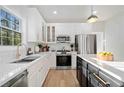 Modern kitchen boasts white cabinetry, stainless steel appliances, and hardwood floors at 139 Thunder Ridge Ln, Acworth, GA 30101