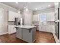 Modern kitchen features white cabinets, stainless steel appliances, an island and hardwood floors at 3139 Hilltop Drive, Marietta, GA 30066