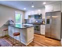 Modern kitchen with stainless steel appliances, white cabinets, and a sleek breakfast bar at 2210 Cumberland Se Ct, Smyrna, GA 30080