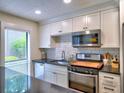 Bright kitchen featuring granite countertops, subway tile backsplash, and stainless steel appliances at 2210 Cumberland Se Ct, Smyrna, GA 30080