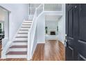 Bright foyer featuring hardwood floors, stairs leading to the second level, and views to the living room at 4001 English Valley Dr, Ellenwood, GA 30294