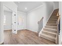 Bright entryway featuring wood floors, staircase with black railings, and glass doors leading to another room at 1619 Tide Mill Road, Cumming, GA 30040