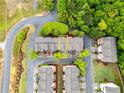 Aerial view of townhomes surrounded by lush greenery and winding roads in a well-planned community at 1646 Sandy Beach Pt, Lawrenceville, GA 30043