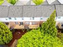 Aerial view of townhome backyards, each with a wooden deck and bordered by mature trees at 1646 Sandy Beach Pt, Lawrenceville, GA 30043