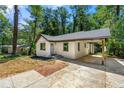 Charming renovated single-story home with a neutral painted brick, covered carport, and brick sidewalk to front door at 2133 Trailwood Rd, Decatur, GA 30032