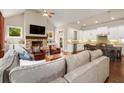 Open-concept living room with a fireplace, vaulted ceiling, and an adjacent kitchen with a breakfast bar at 2700 Vinings Orchard Cir, Atlanta, GA 30339