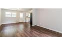 Open-concept living area featuring sleek hardwood flooring, light walls, and access to kitchen at 4820 Oak Grove Dr, Cumming, GA 30040