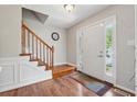Inviting foyer with hardwood floors, wooden staircase, and natural light streaming through the front door's sidelights at 1679 Summit Place Way, Loganville, GA 30052