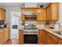 Well-equipped kitchen with stainless steel appliances, granite countertops, oak cabinets, and tiled backsplash at 1679 Summit Place Way, Loganville, GA 30052