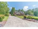 Long driveway leading to a brick home with beautiful landscaping and mature trees at 3510 Eagle Landing Dr, Snellville, GA 30039