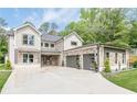 Beautiful home with white brick, stone accents, three-car garage, and long concrete driveway at 1273 Grayson Pkwy, Grayson, GA 30017
