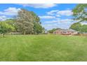 Spacious backyard featuring a large lawn, mature trees, and a wooden fence at 1419 Gates Mill Walk, Lawrenceville, GA 30045