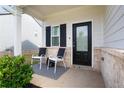 Inviting front porch with seating, complemented by a stylish rug, black door, and brick accents, offering a cozy outdoor space at 217 Limestone Cir, Conyers, GA 30013