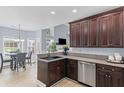 Kitchen features dark wood cabinets, granite countertops, stainless steel appliances, and dining area at 5928 Edenfield Nw Dr, Acworth, GA 30101
