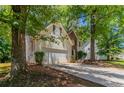Well-maintained home with an attached two-car garage and a mature tree in the front yard at 3470 River Mill Ln, Ellenwood, GA 30294