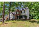 Inviting two-story home with a brick facade, lush lawn, and a mature tree at 3470 River Mill Ln, Ellenwood, GA 30294