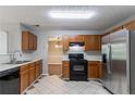 Functional kitchen with wood cabinets, black appliances, and neutral countertops at 3470 River Mill Ln, Ellenwood, GA 30294