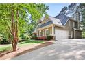 A beautiful home showing an attached garage, driveway and lush, mature landscaping at 4711 Oakleigh Manor Dr, Powder Springs, GA 30127