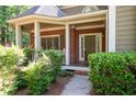 Inviting brick front porch with manicured landscaping and covered entryway to the home at 4711 Oakleigh Manor Dr, Powder Springs, GA 30127