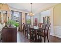 Formal dining room with hardwood floors, wainscoting, and chandelier lighting at 8045 Depford Way, Cumming, GA 30041
