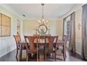 Formal dining room with hardwood floors, wainscoting, and chandelier lighting at 8045 Depford Way, Cumming, GA 30041