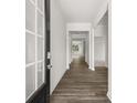 Inviting hallway with wood-look flooring, white trim and neutral paint leads to rooms filled with natural light at 408 Oak View Ln, Dallas, GA 30157