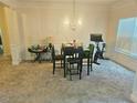 Dining room featuring crown molding, carpet, and a classic chandelier at 4925 Locherby Dr, Fairburn, GA 30213