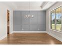 Beautiful dining room with wainscoting, tray ceiling, chandelier and hardwood floors at 1609 Tielman Way, Snellville, GA 30078