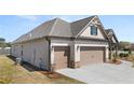 Side view of a brick and stone home showcasing the two-car garage at 1609 Tielman Way, Snellville, GA 30078
