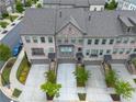 Aerial view of townhome exteriors featuring brick facade, attached garages, and landscaped lawns at 3 Hundley Ln, Roswell, GA 30076