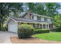 View of the brick home's exterior with a garage, showcasing its architectural style and well-maintained landscaping at 3824 N Cooper Lake Se Rd, Smyrna, GA 30082