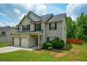 Charming home boasts a brick and siding exterior, complemented by a lush green lawn and blue skies at 917 Revere Way, Hampton, GA 30228