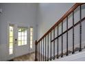 Bright foyer features wood floors, elegant staircase with iron spindles, and natural light at 917 Revere Way, Hampton, GA 30228