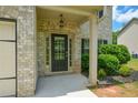 Elegant front entrance with a classic black door, sidelights, and manicured landscaping at 917 Revere Way, Hampton, GA 30228