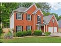 A beautiful two-story brick home with black shutters and well-kept landscaping surrounding the property at 135 Clubhouse Nw Dr, Kennesaw, GA 30144
