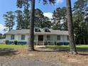 Charming single story home with a white facade, blue trim, dormer windows, and a welcoming front porch at 1833 Stephenson Rd, Lithonia, GA 30058