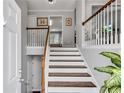 Inviting entryway featuring wood and white stairs leading to the upper level at 607 Lexington Way, Woodstock, GA 30189