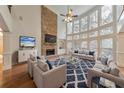 Bright living room with soaring windows, stone fireplace, and elegant furnishings at 1575 Petal Nw Pt, Kennesaw, GA 30152