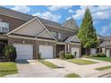 A row of brick townhomes, each with a one-car garage and neatly trimmed green spaces, offering a sense of community at 2555 Flat Shoals Rd # 1405, College Park, GA 30349