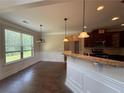 Open-concept kitchen with granite countertops, dark wood cabinets, and pendant lighting at 381 Plymstock Dr, Mcdonough, GA 30253