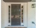 Elegant front door with sidelights, painted in a stylish dark gray with white trim at 703 Alvis Ln, Norcross, GA 30093