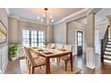 Bright dining room with a chandelier, a large window, and access to the staircase and front door at 1300 Winfair Ne Ln, Brookhaven, GA 30329
