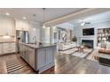 Open-concept kitchen and living room area featuring an island, stainless steel appliances, and a cozy fireplace at 1300 Winfair Ne Ln, Brookhaven, GA 30329