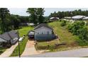Cozy home with a deck, a large lawn, mature trees, and a unique carport underneath the rear of the house at 380 South St, Buford, GA 30518