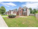 Suburban home with brick facade, two-car garage, and lush green lawn at 330 Kentwood Springs Dr, Hampton, GA 30228