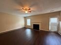 Bright living room with hardwood flooring, a cozy fireplace, ceiling fan, and access to the outdoors at 330 Kentwood Springs Dr, Hampton, GA 30228