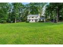 White home with a spacious lawn, framed by mature trees, offering a serene setting at 5290 River Mill Cir, Marietta, GA 30068